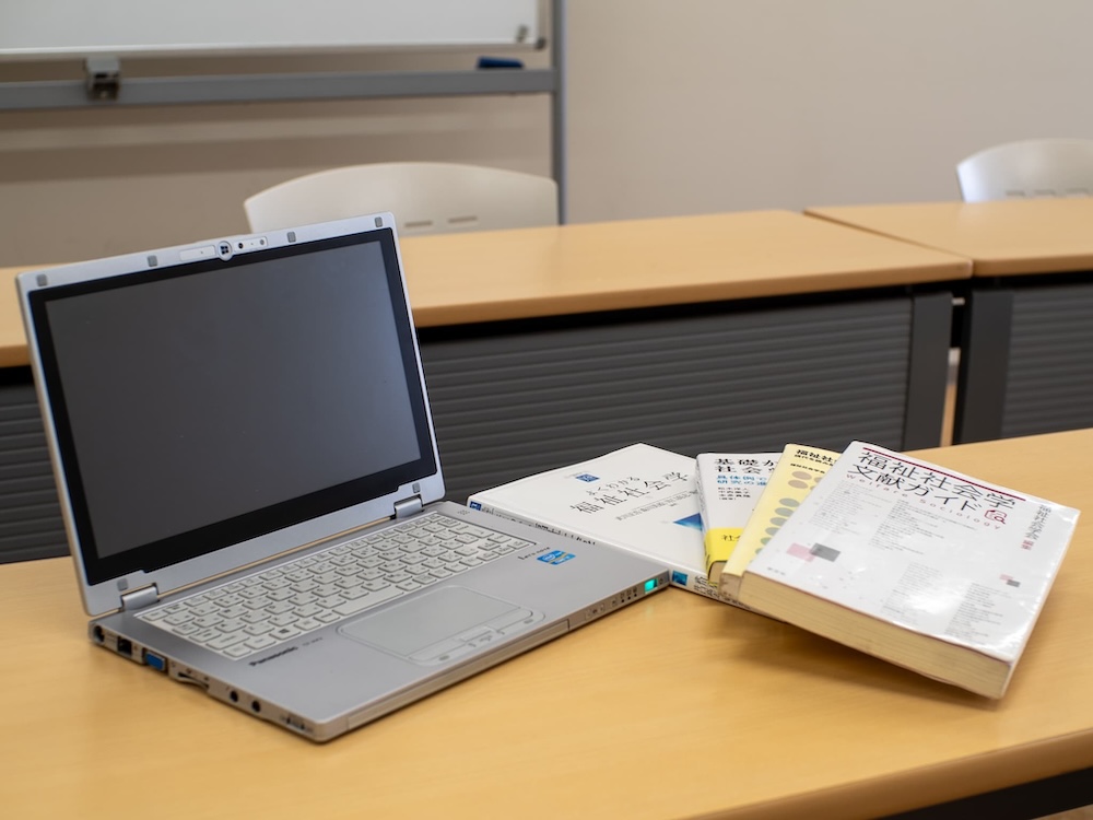 机の上にノートパソコンが開いている写真